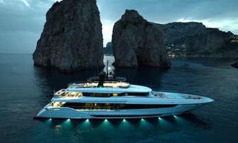 Private yacht charter HALARA at anchor at night by rock formations