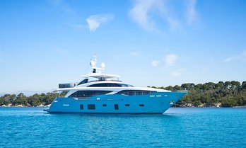 Charter yacht ANKA at anchor with green foliage in the background