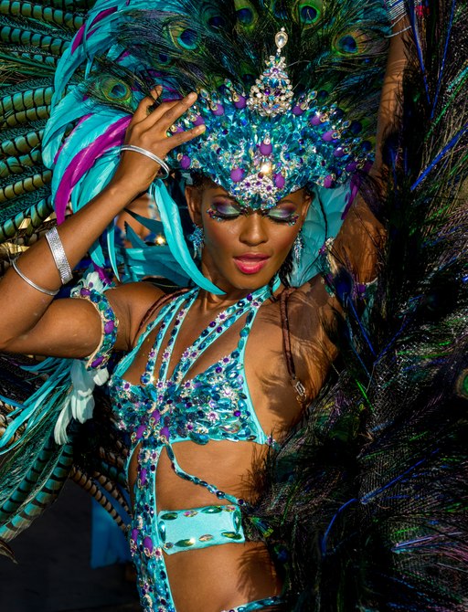 A dancer wearing a lavish costume of peacock feathers