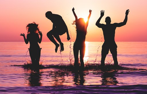 Young people silhouetted against a setting sun in Ibiza